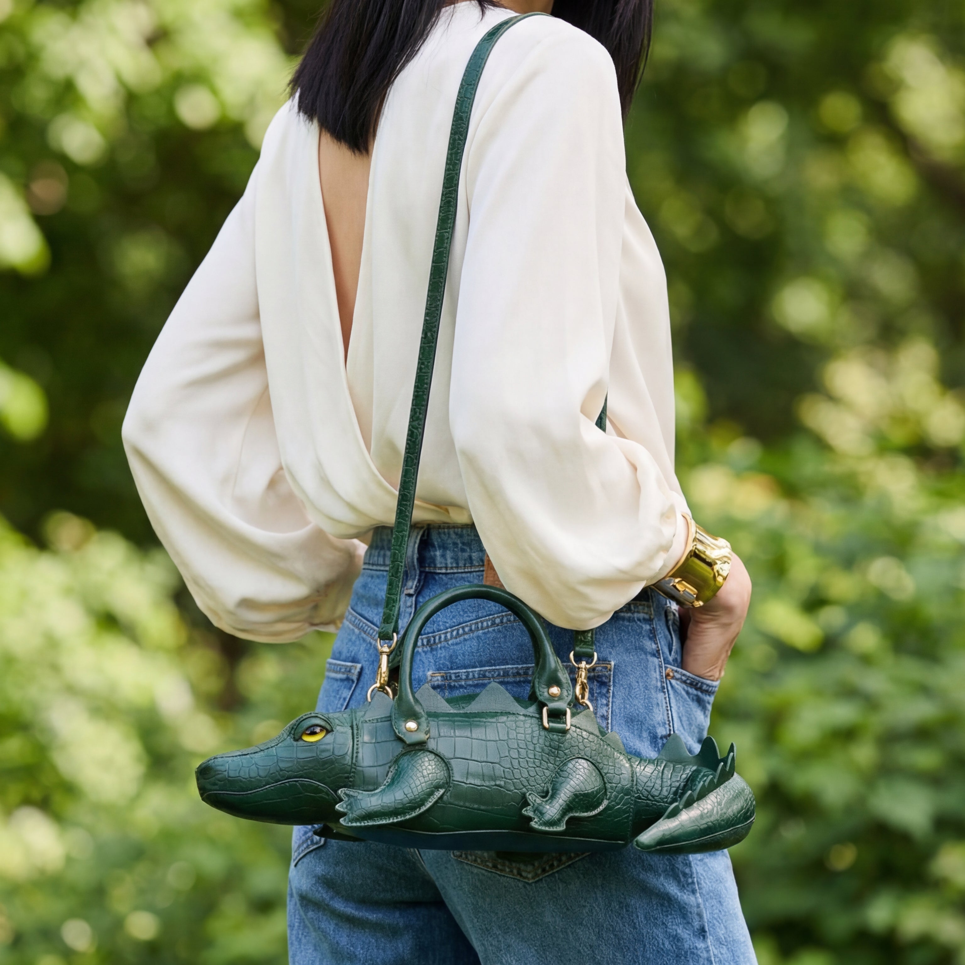 Woman holding a green handbag with a blurred green background