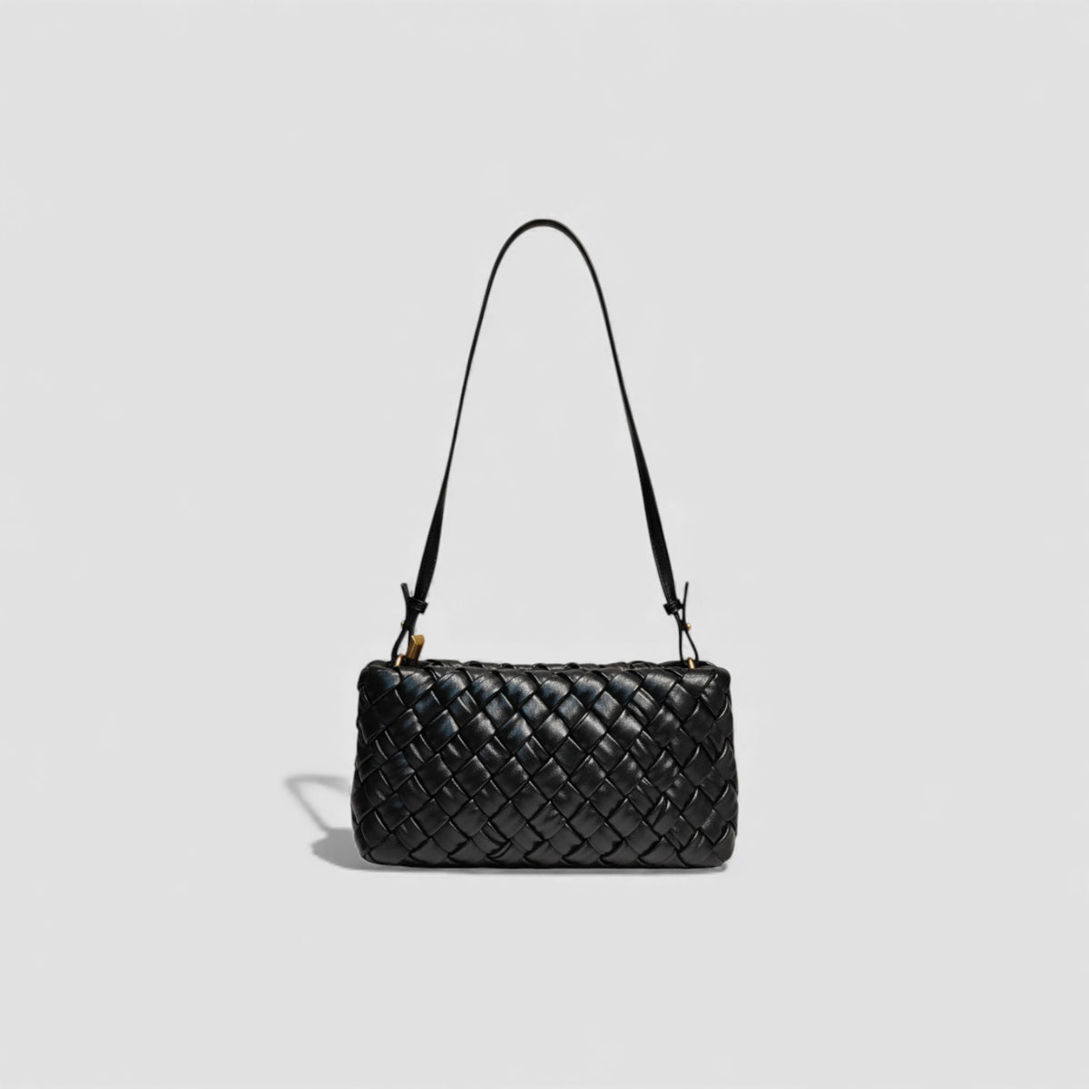 Black woven handbag on a light gray background