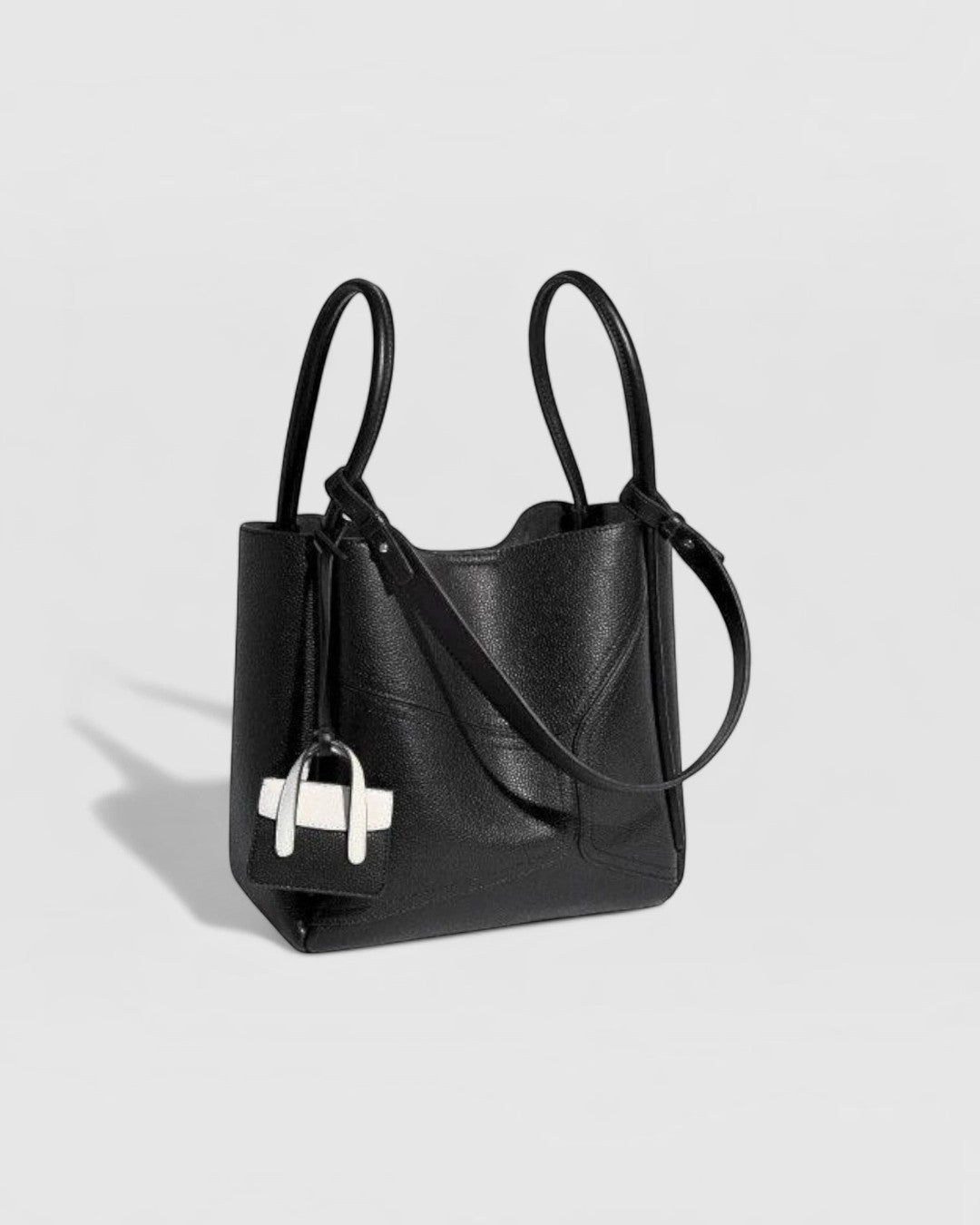 Pine Drew India Becca black vegan leather tote bag with gold hardware, dual handles, and a detachable shoulder strap.