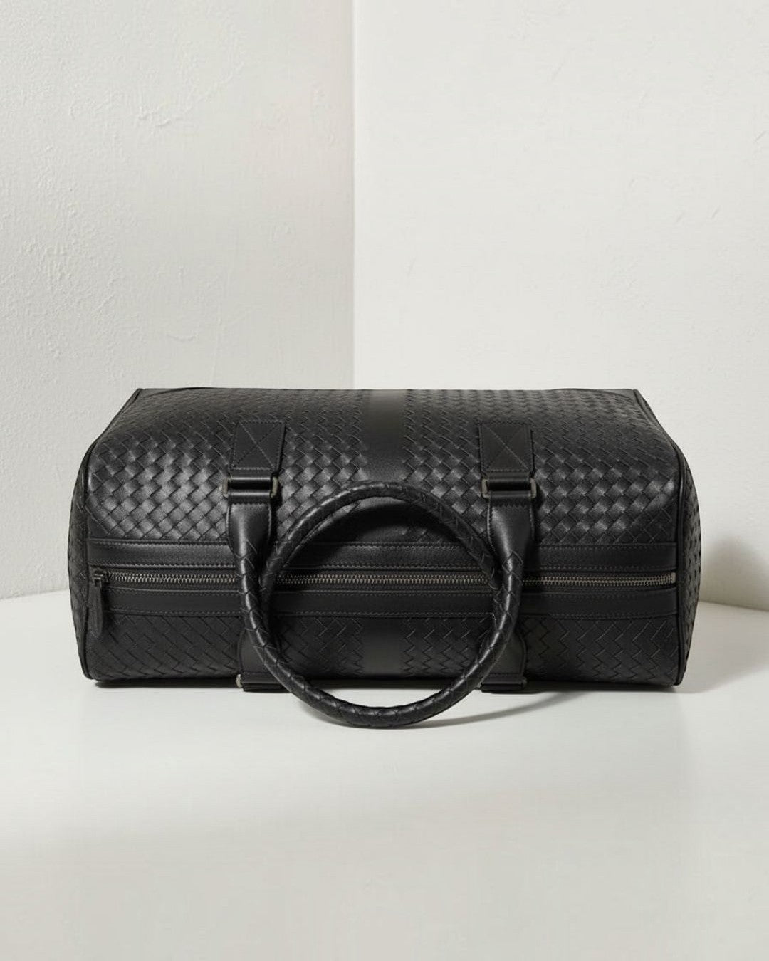 Pine Drew India black leather Monaco woven duffle bag with circular handles and structured zip closure design