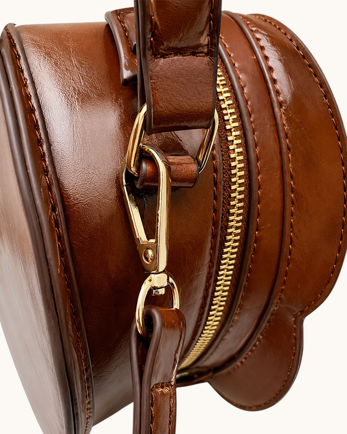 Pine Drew India cognac vegan leather bag side view showing gold hardware and strap attachment