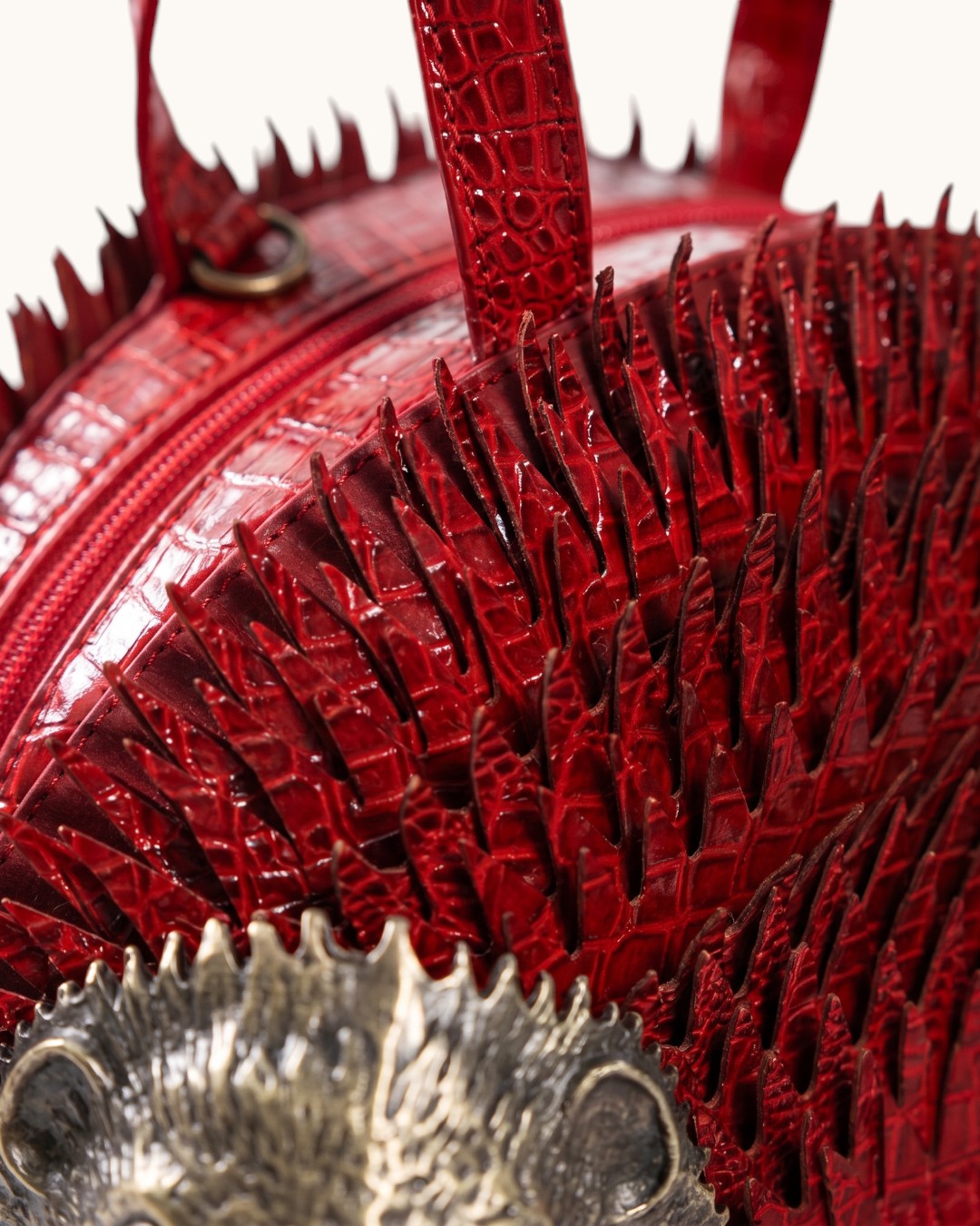 Pine Drew India Épinelle Mini bag in deep crimson croc-embossed vegan leather with sculpted spines and brass hedgehog face
