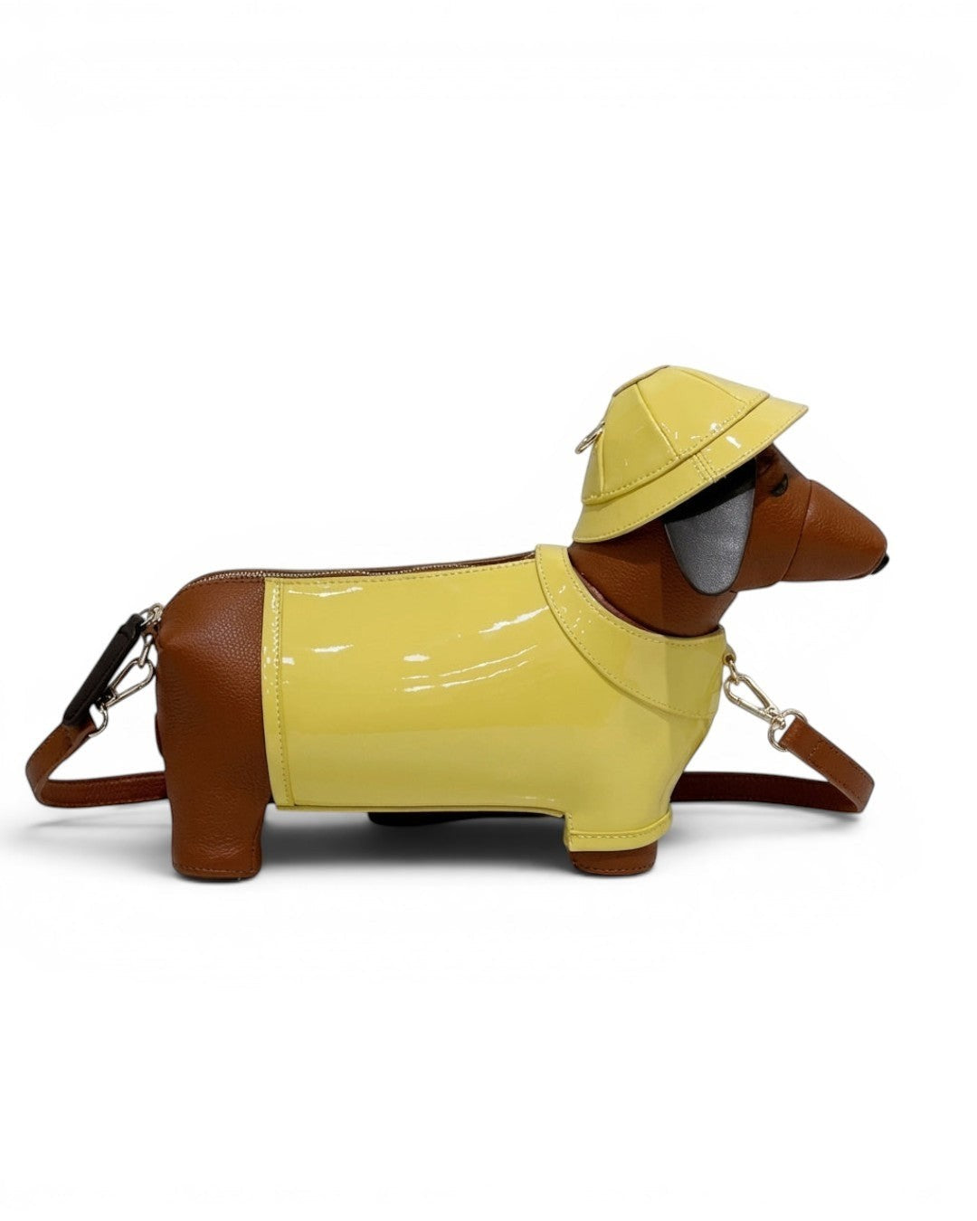 Pine Drew India dachshund shaped safari bag in brown vegan leather with a glossy yellow trench coat and matching hat.