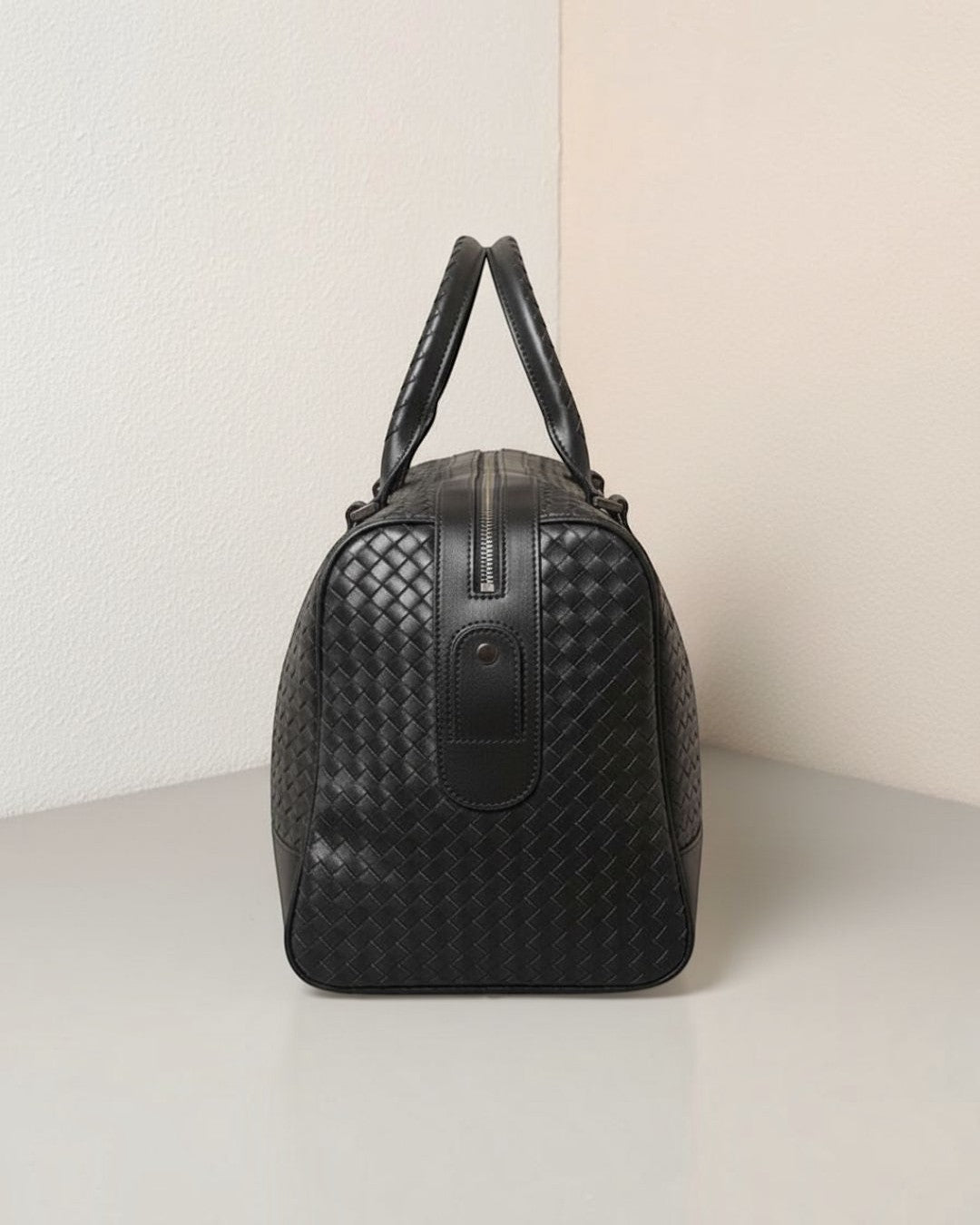 Pine Drew India Monaco woven black leather duffle bag side view with reinforced handles and zip closure