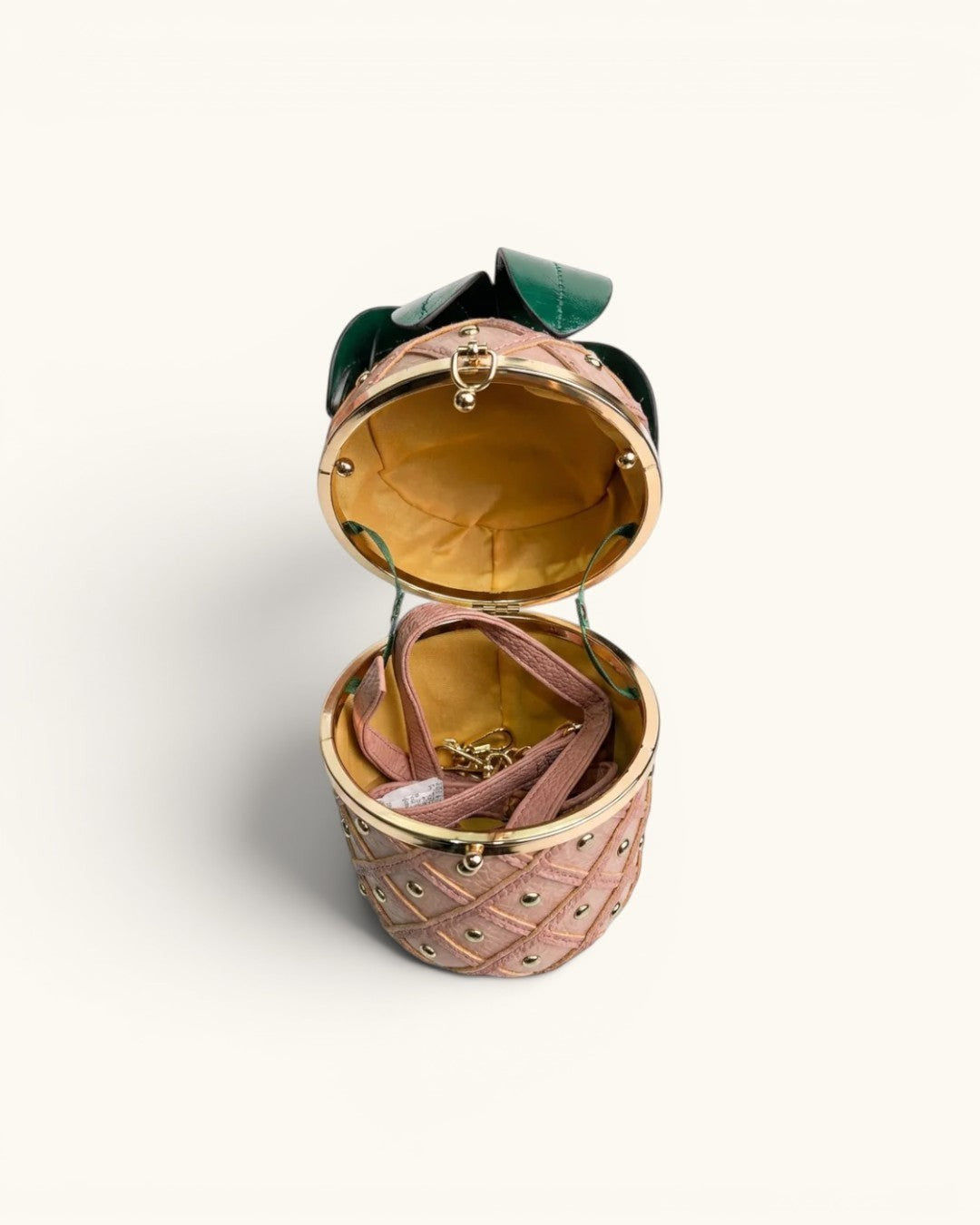 Pine Drew India Palmiera pineapple-shaped vegan leather clutch in pink with gold studs and emerald green leaf crown