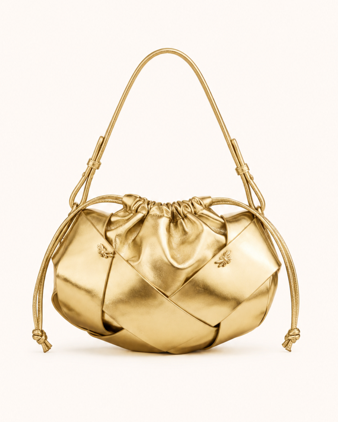 A metallic gold handbag with a unique geometric, folded panel design, a drawstring top, and a matching top handle, shown against a plain off-white background.
