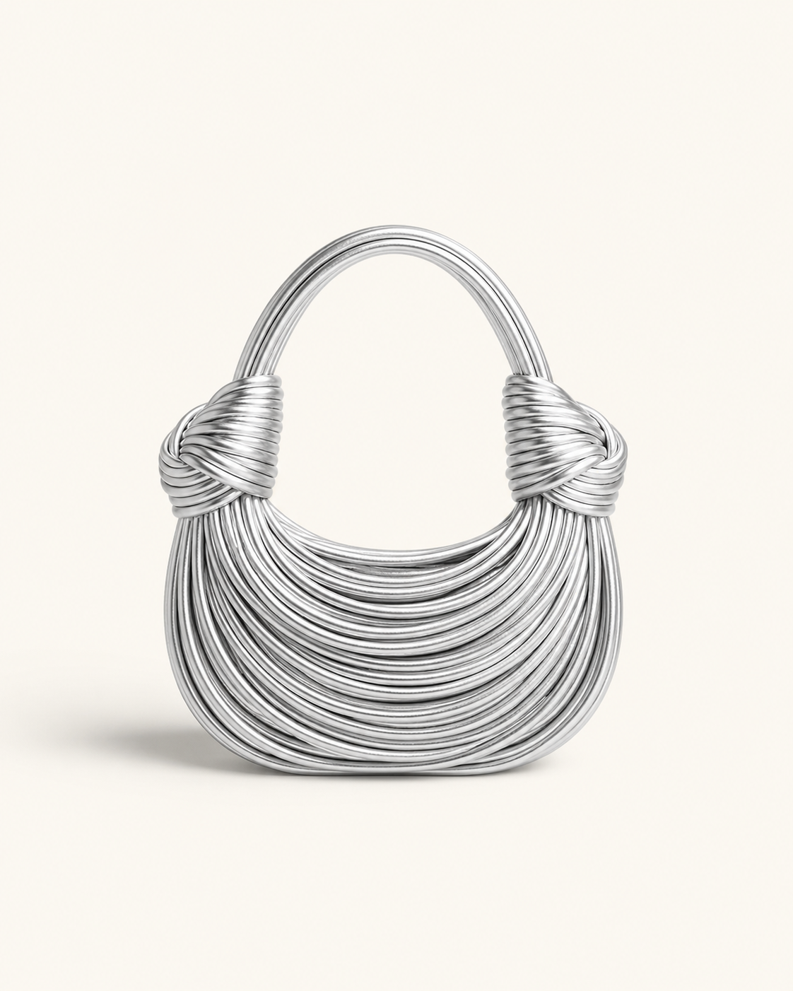 A silver metallic handbag with a crescent-shaped body, knotted handle attachments, and a curved top handle, shown on a plain off-white background.