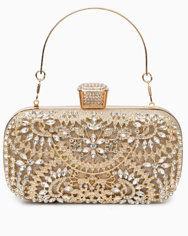 A luxurious gold clutch bag featuring an intricate metal flower design adorned with sparkling rhinestones, with a shoulder strap included.