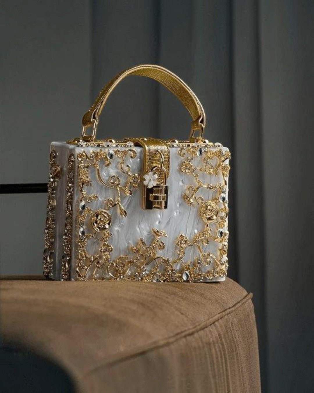 Pine Drew India Bella Box handbag in white acrylic with intricate gold-plated floral filigree and a secure lock.