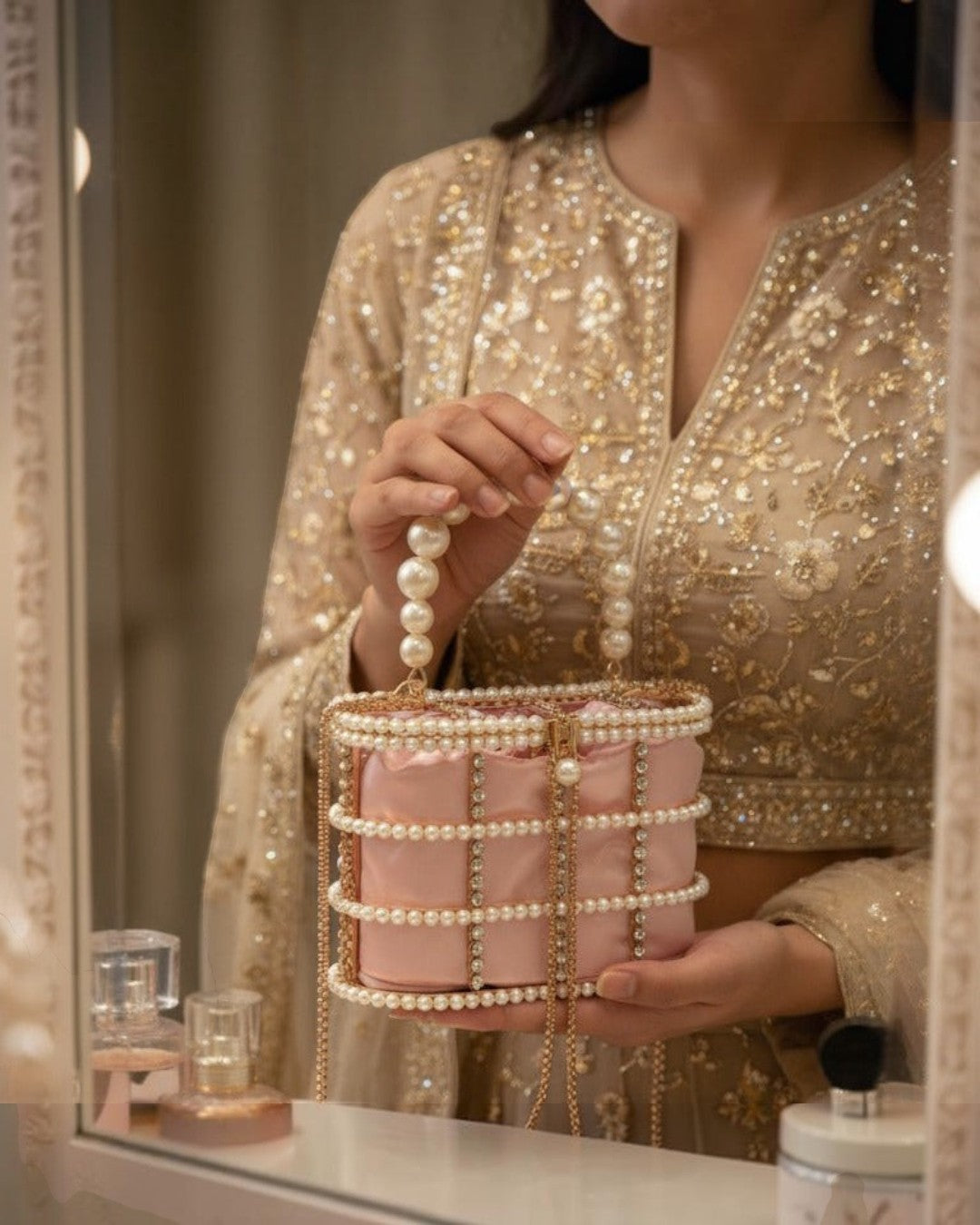 Pine Drew India blush satin casket bag with pearl and crystal lattice overlay and a sculptural pearl handle.
