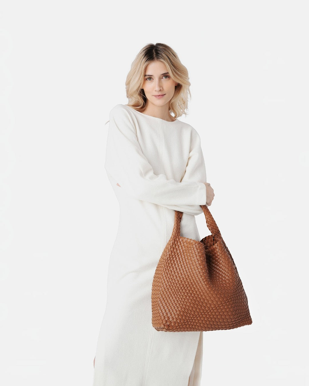 Pine Drew India model carrying a brown handwoven vegan leather Jocelyn bag with a slouchy sculptural design