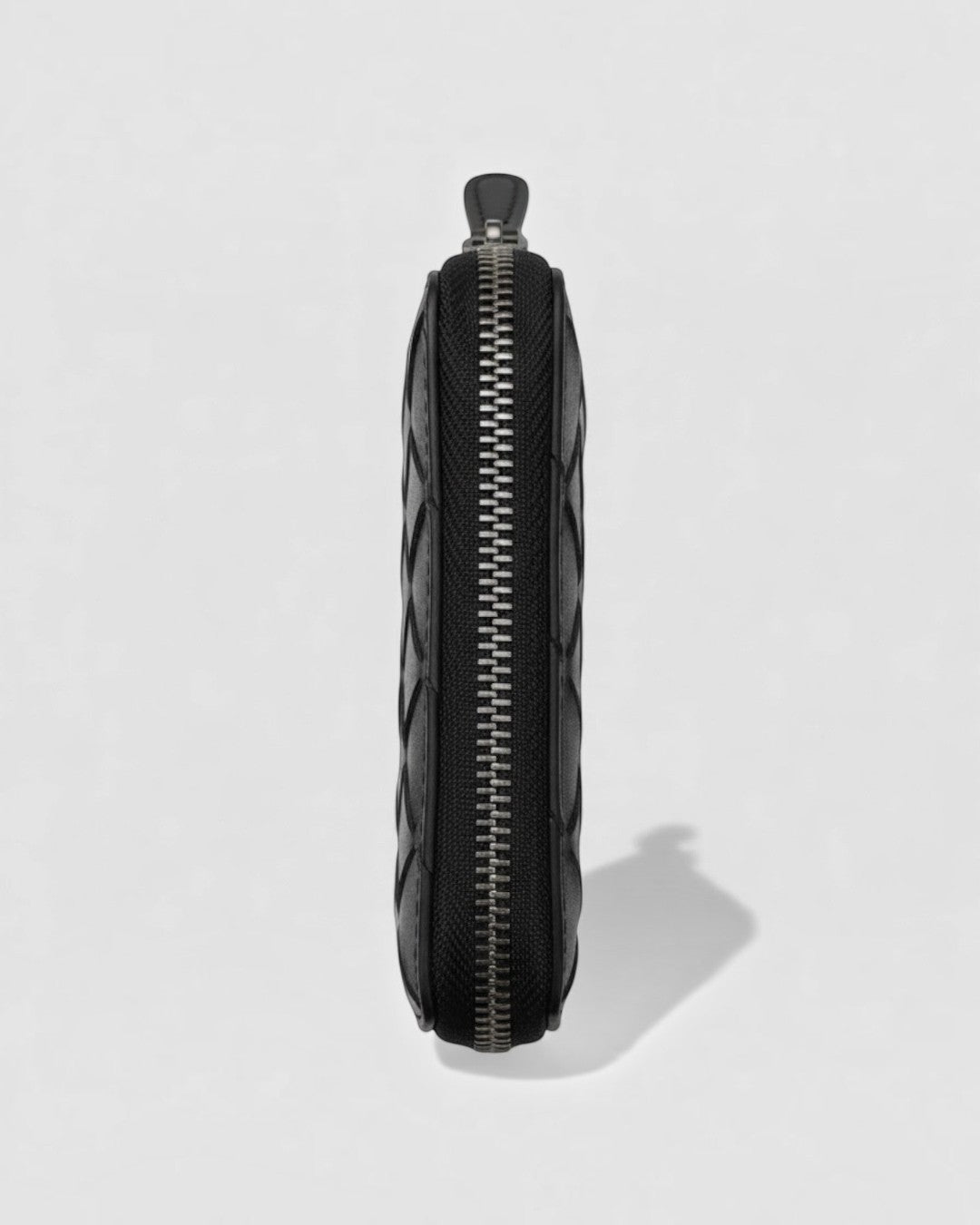 Pine Drew India Caden Interlace zip wallet in black woven leather, showing a side profile with metal zipper detail.
