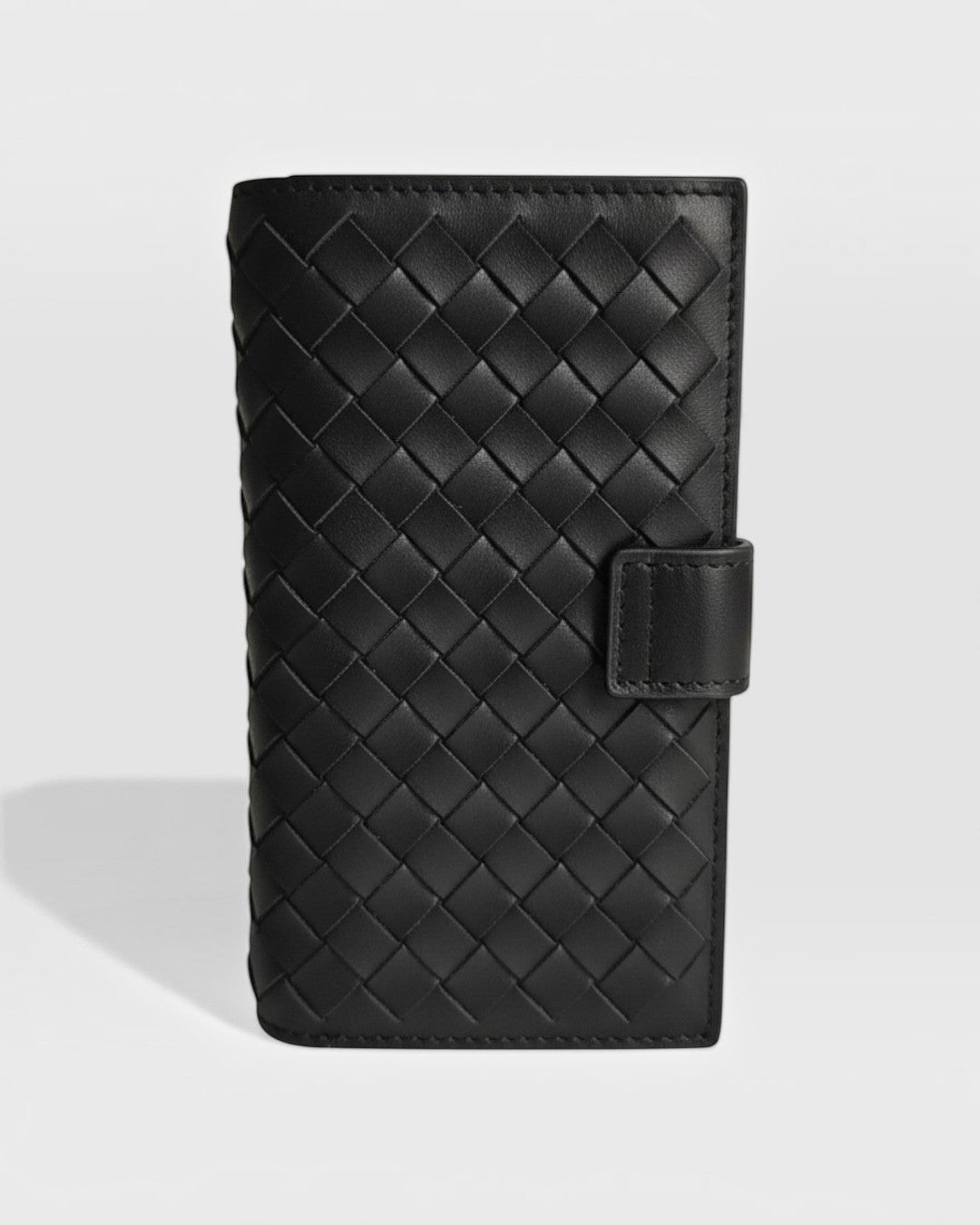 Pine Drew India Caden Interlace long wallet in black woven leather with a structured silhouette and snap closure.