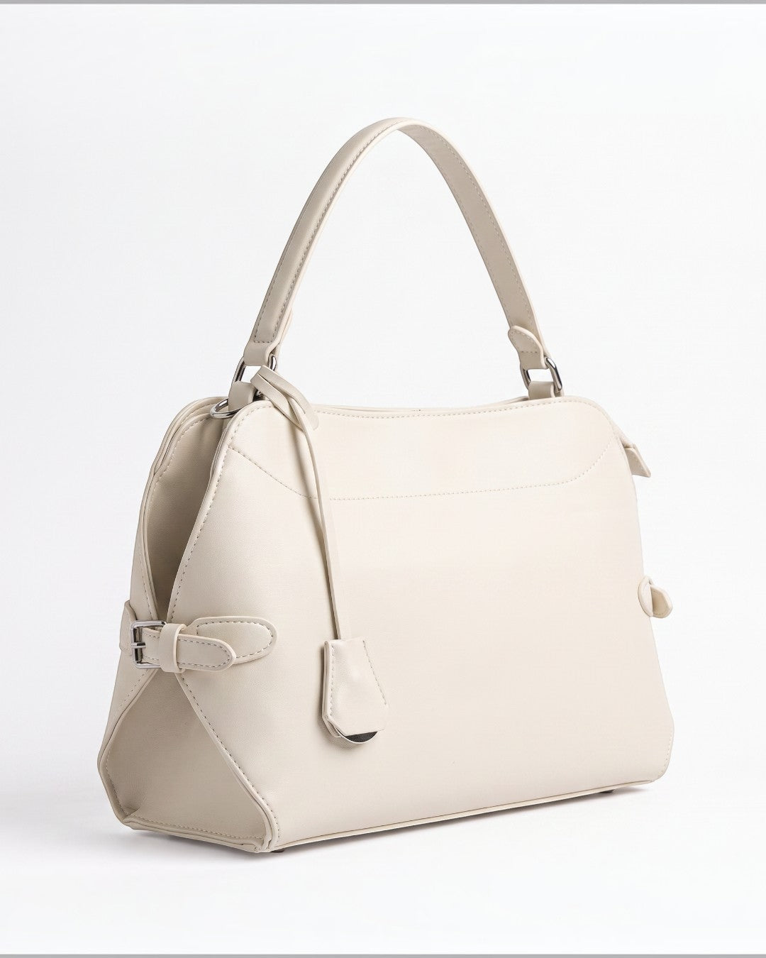 Pine Drew India Celeste hobo bag in cream leather with gold hardware, top handle, and a sleek, sculpted silhouette.