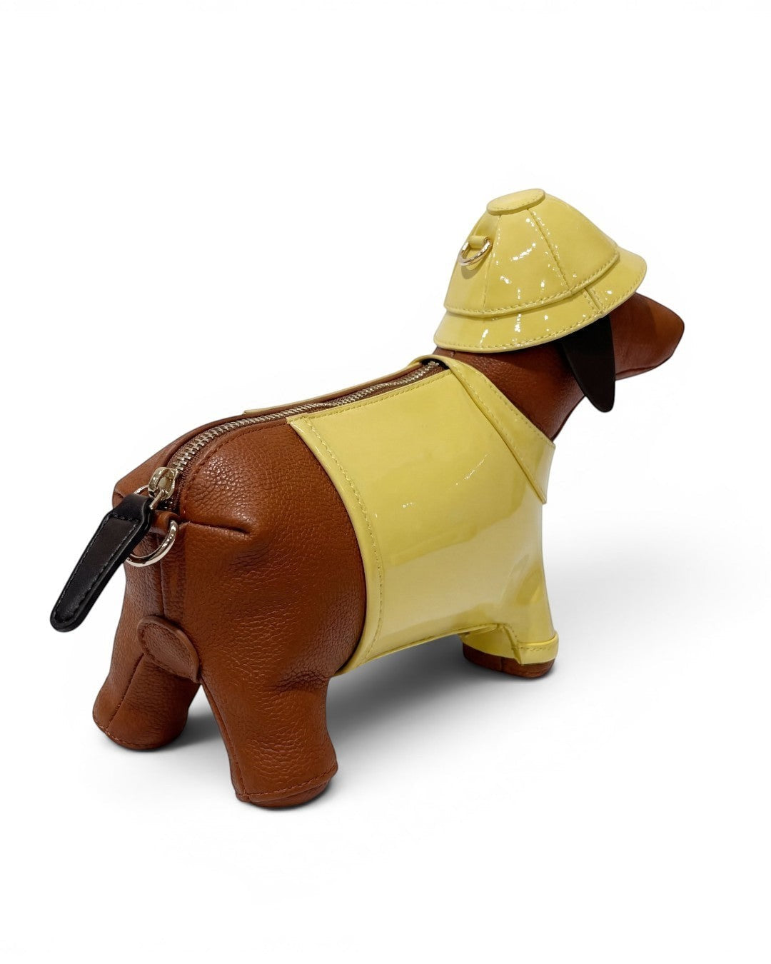 Pine Drew India brown vegan leather dachshund-shaped bag with a glossy yellow trench coat and matching safari hat.