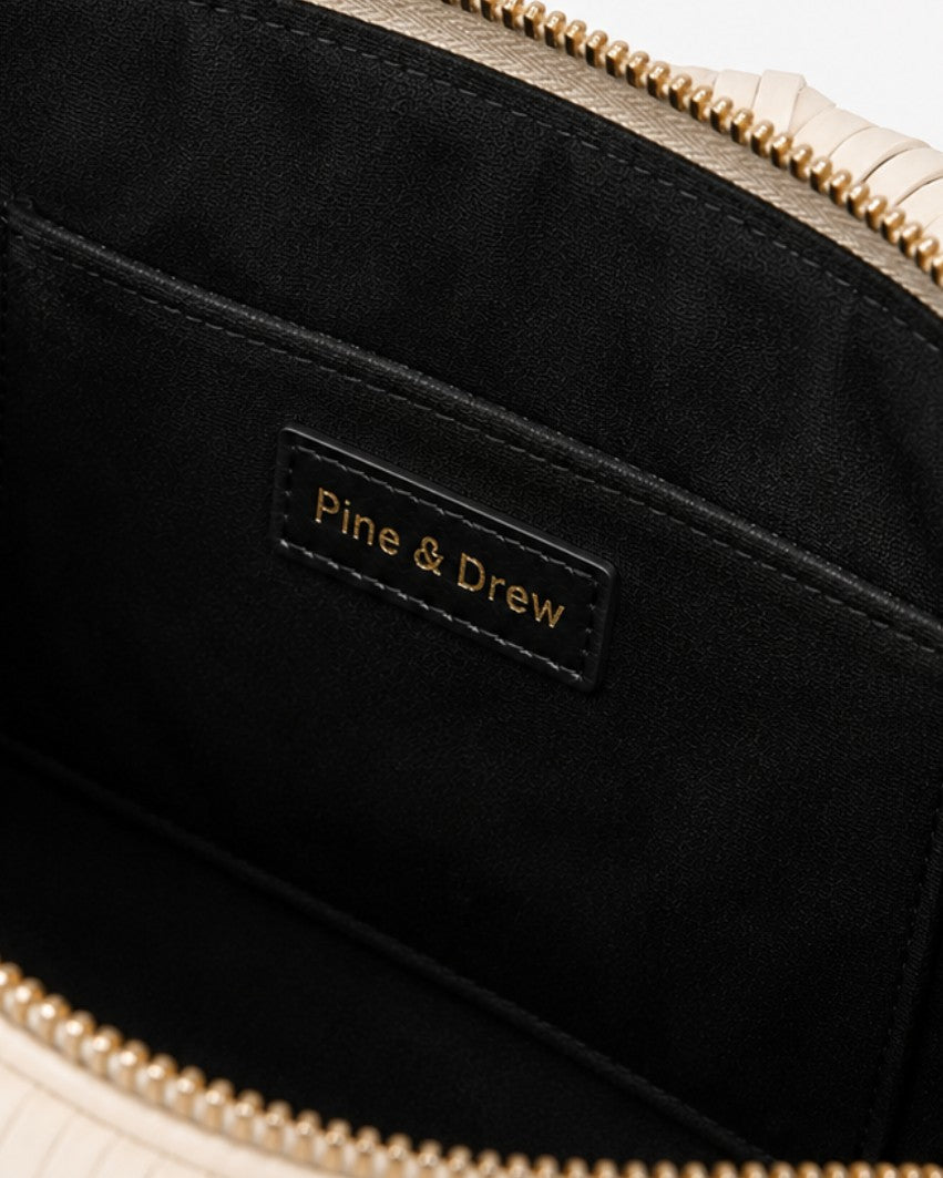 Pine Drew India Fringe Pup Couture Bag interior featuring black lining, gold zipper, and branded leather patch