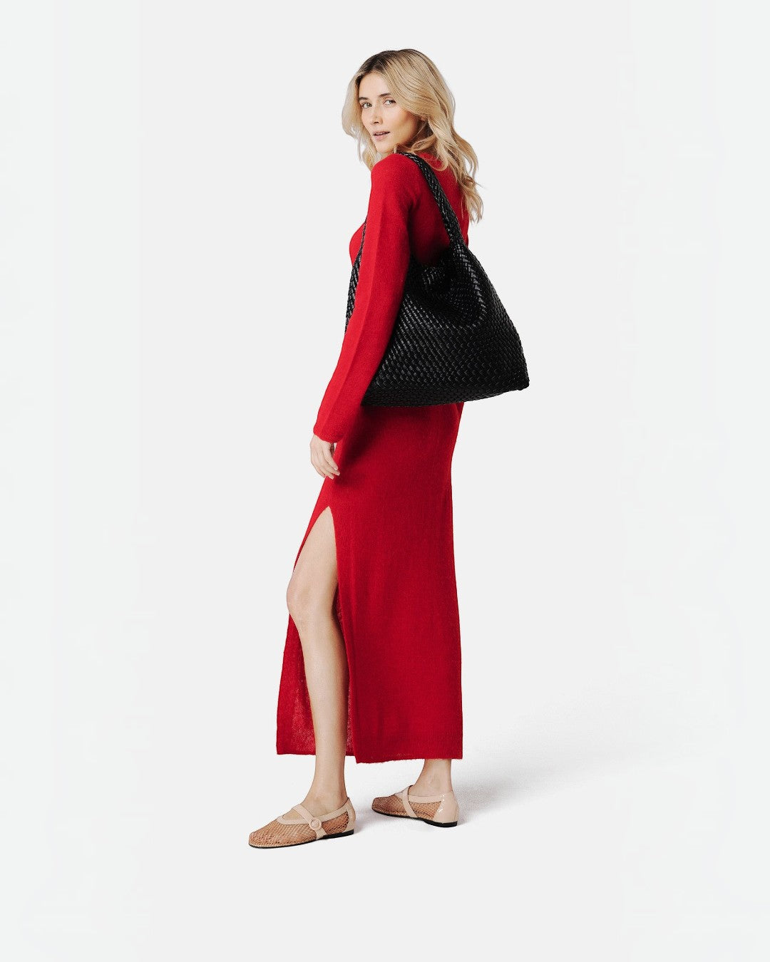 Model wearing a red dress and carrying a Pine Drew India black handwoven vegan leather Jocelyn shoulder bag