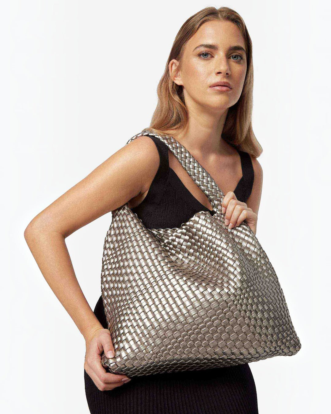 Pine Drew India The Jocelyn handwoven metallic silver vegan leather slouchy shoulder bag worn by a woman
