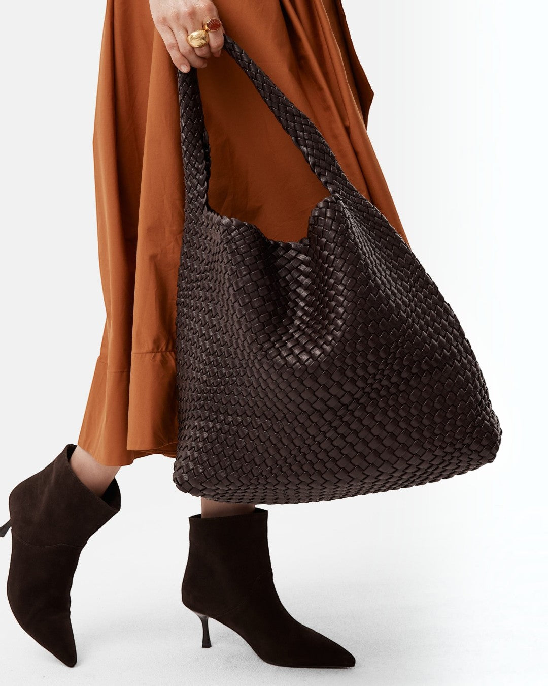 Pine Drew India The Jocelyn handwoven dark brown vegan leather slouchy shoulder bag carried by a woman