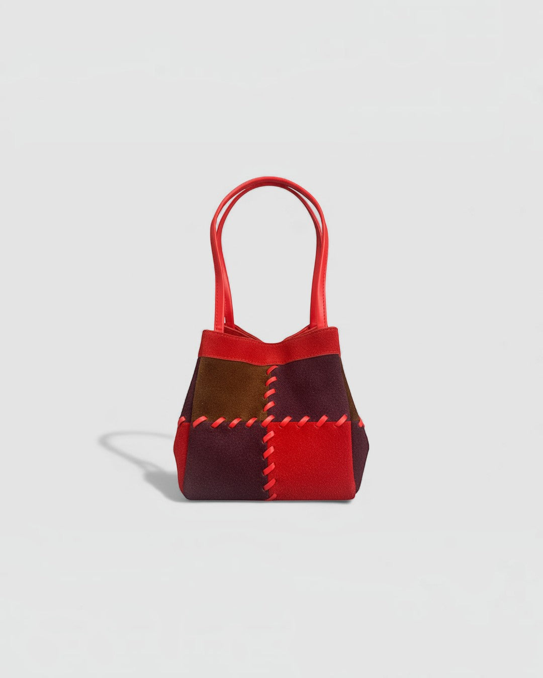 Pine Drew India Luna Mosaic handbag in multi-tone suede and leather with red arc handles and contrast whipstitching.