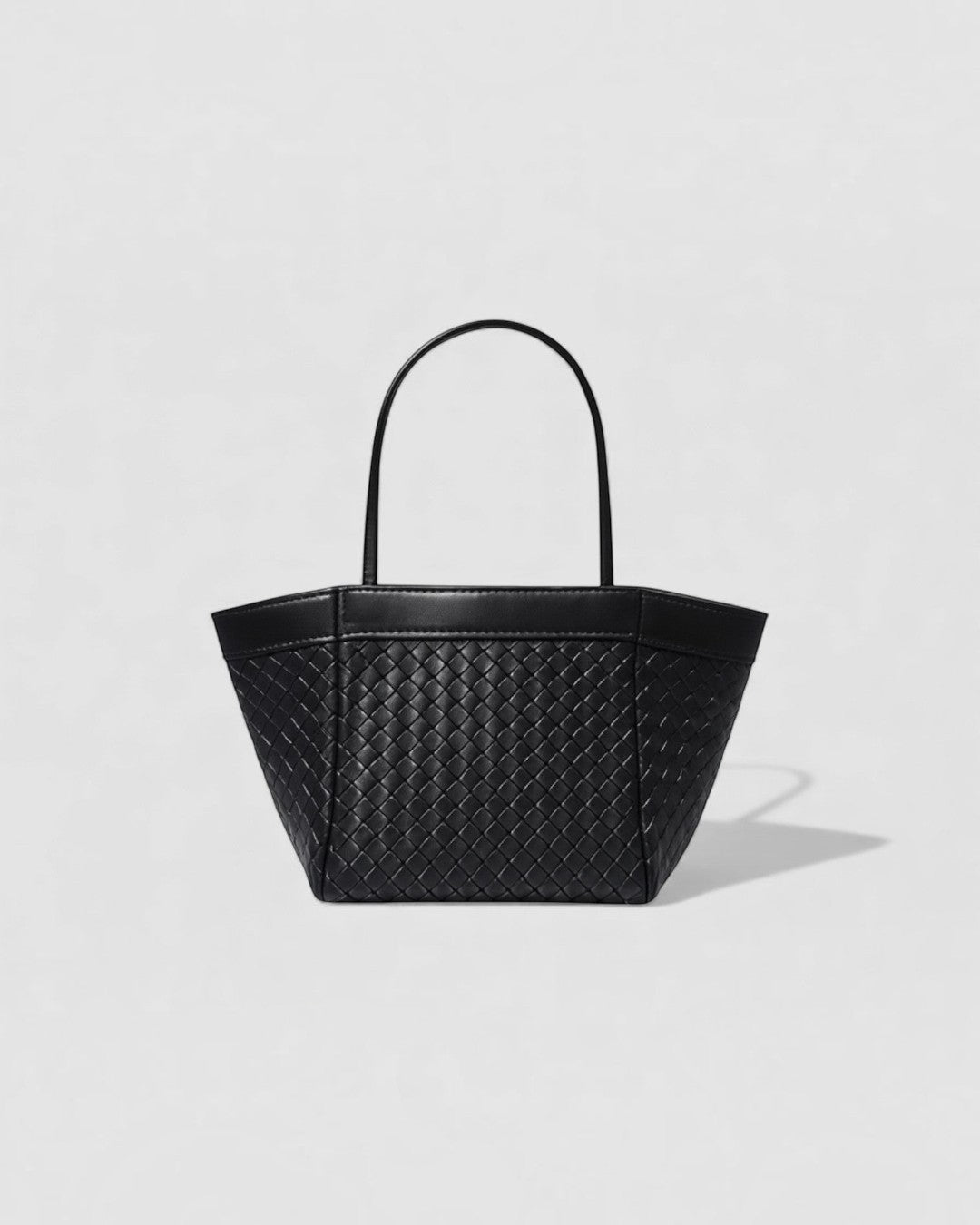 Pine Drew India Luna handbag in espresso brown full-grain leather with an intricate handwoven exterior and arc handles.