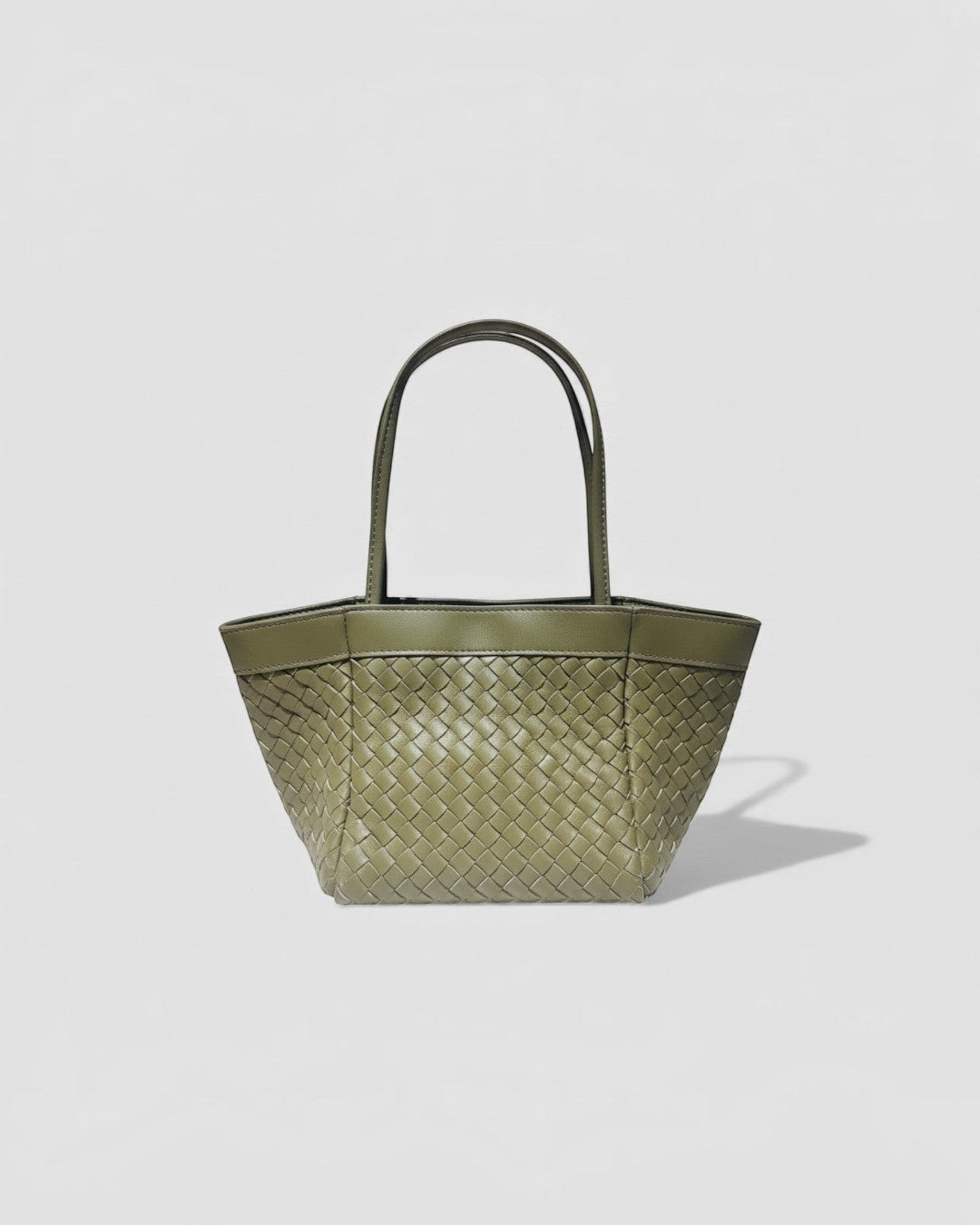 Pine Drew India Luna handbag in olive green woven leather with a structured silhouette and dual top handles.