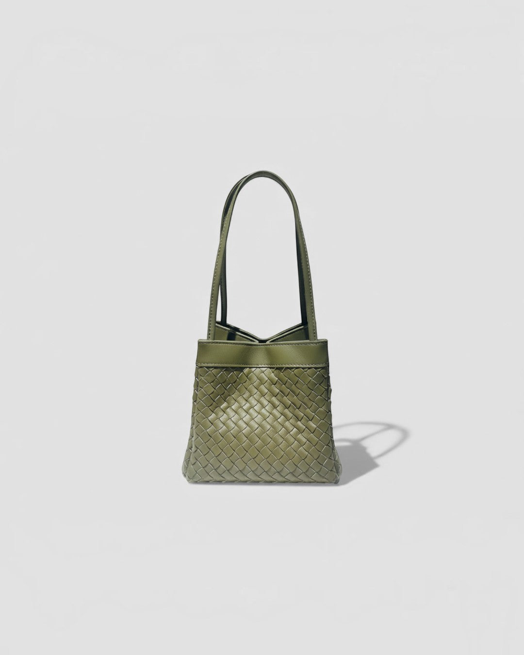 Pine Drew India Luna Verdura olive green woven leather handbag with architectural arc handles and structured shape.