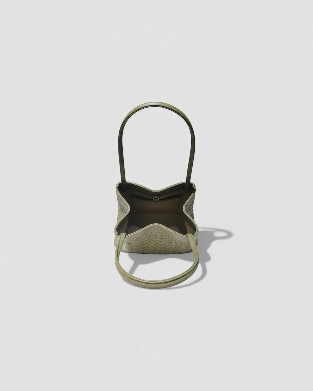 Pine Drew India Luna Verdura olive green woven leather handbag with architectural arc handles and structured shape.