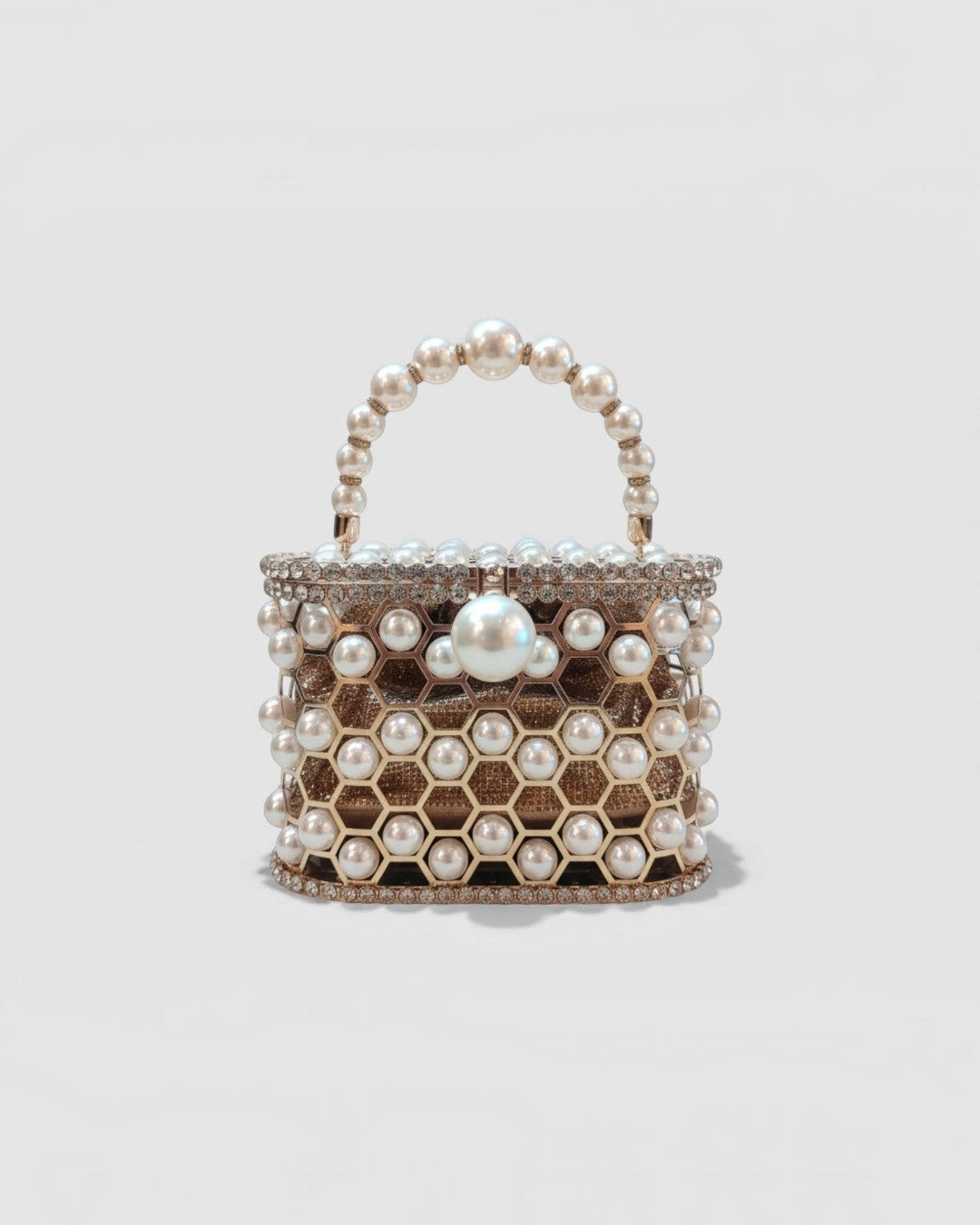 Pine Drew India Aurelia Pearl Lattice minaudière in champagne gold with a honeycomb structure and pearl embellishments.