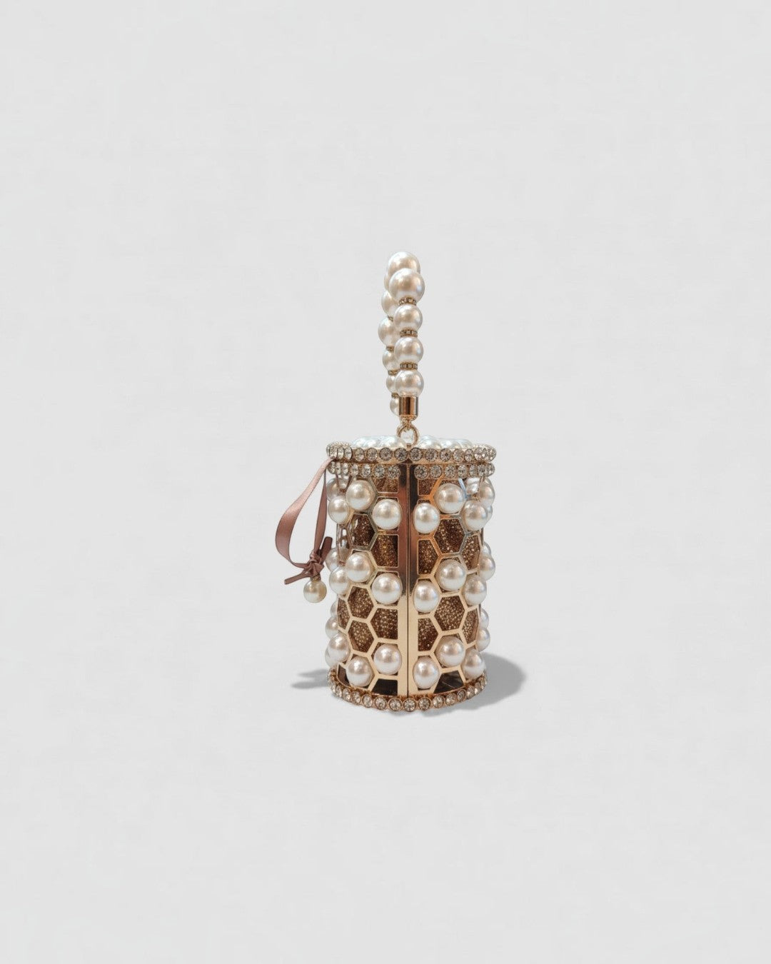 Pine Drew India Aurelia Pearl Lattice minaudière in champagne-gold with a honeycomb structure and pearl embellishments.
