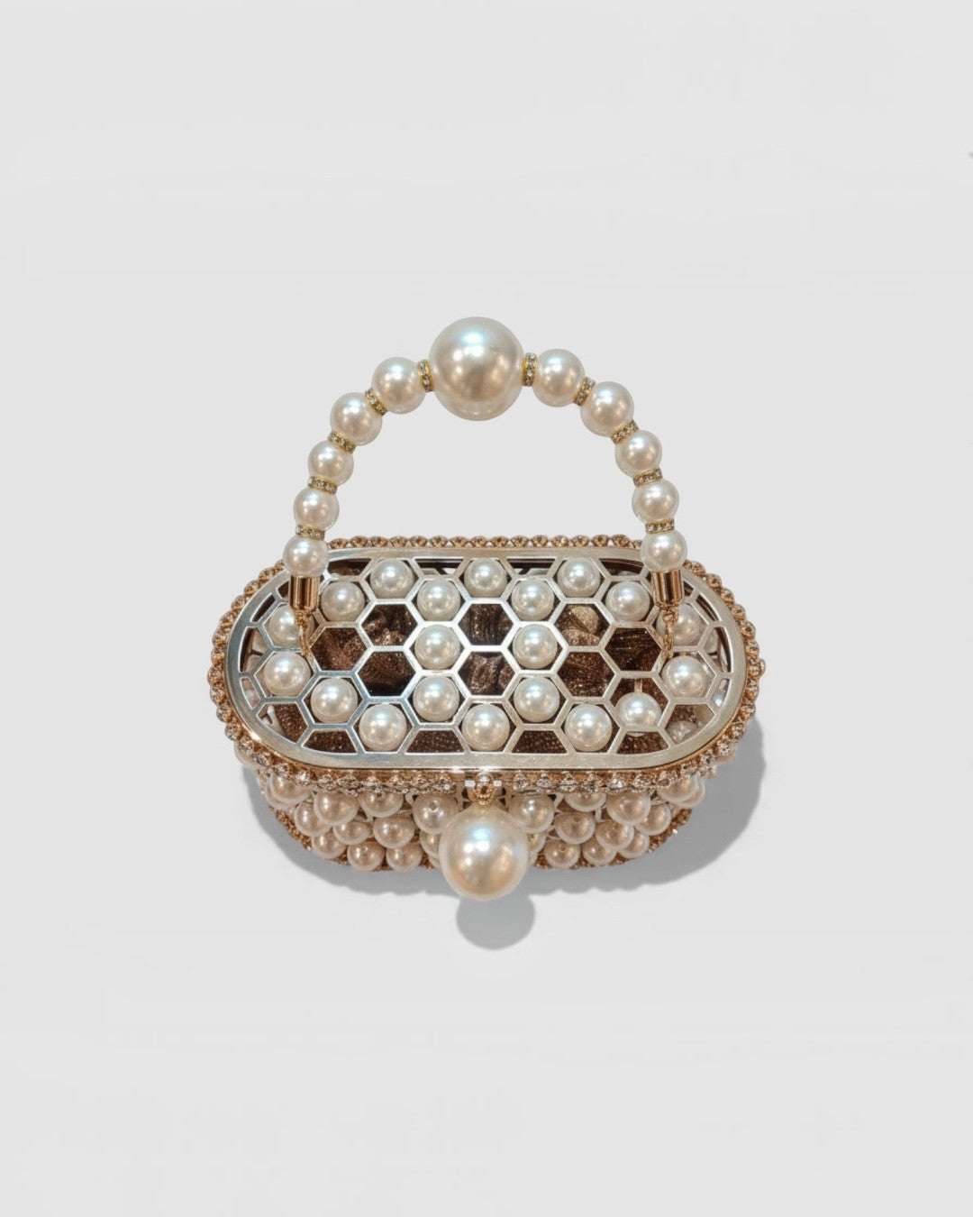 Pine Drew India Aurelia Pearl Lattice minaudière in champagne-gold with a honeycomb structure and pearl embellishments.