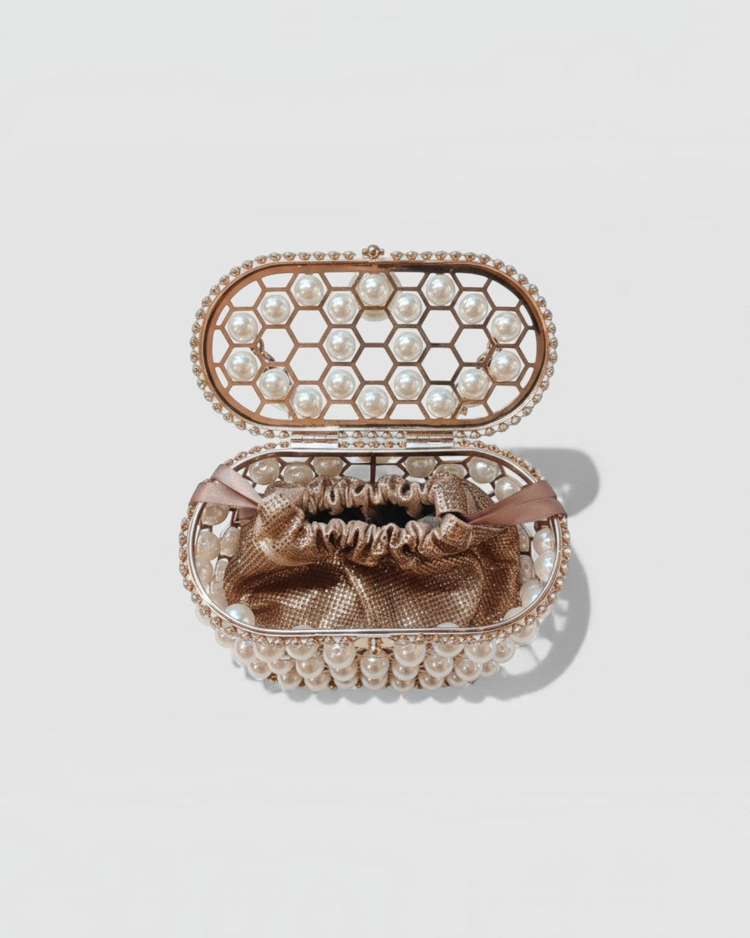 Pine Drew India Aurelia Pearl Lattice minaudière featuring a champagne-gold honeycomb frame with inset luminous pearls.